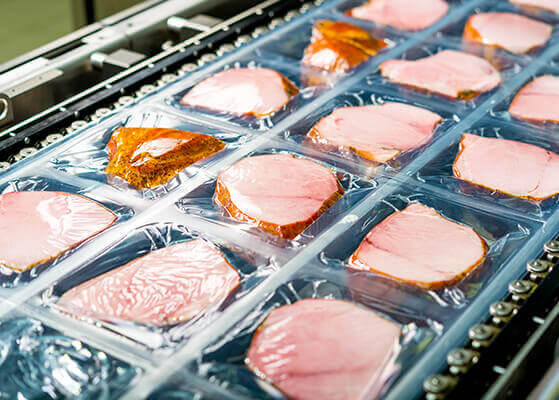 Ham steaks packaged and individually sealed on a production line