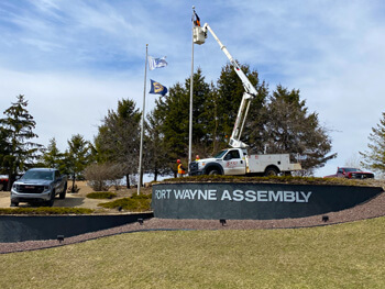 Shambaugh team members utilizing a truck lift to reach a flag pole