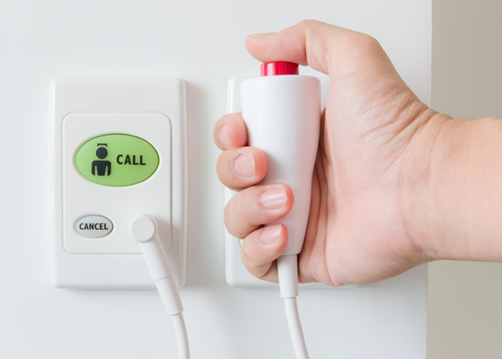 Hand holding a hospital staff call button