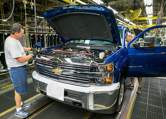 GM team members working on an assembly line production facility