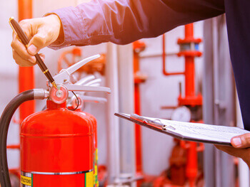 Technician servicing a fire extinguisher