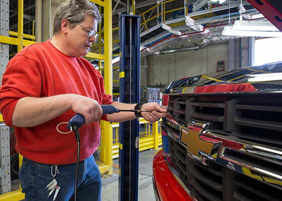 GM team member working on an assembly line production facility