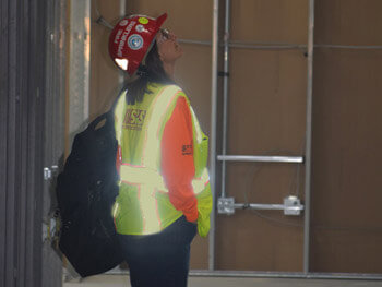 Shambaugh technician wearing safety gear looking up at equipment