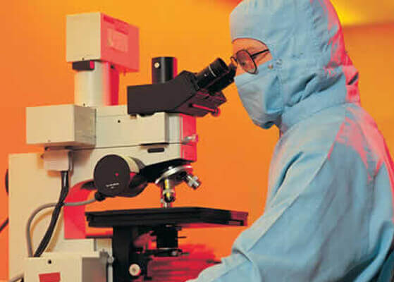 Scientist looking into a microscope